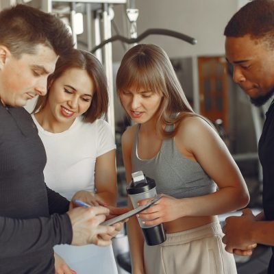Sports people. Group in a sportswear. International friends standing in a gym.