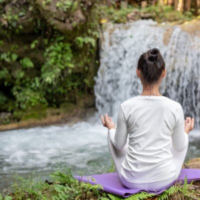 Beautiful girls are playing yoga at the park. Among the natural waterfalls in the forest, exercise concepts